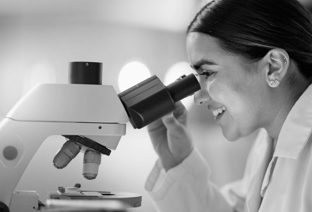 woman looking into microscope